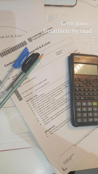 Cambridge International AS and A Level Math exam paper with pens and Casio calculator ready to start